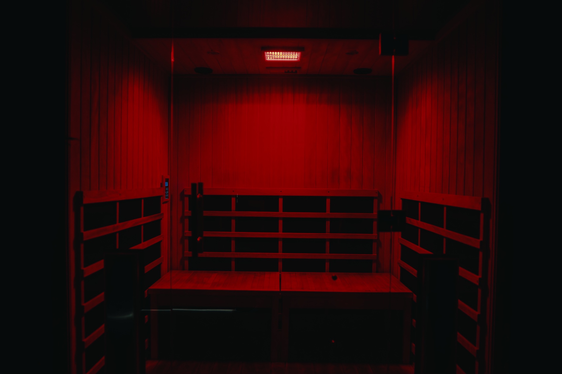 Infrared sauna interior bathed in deep red light