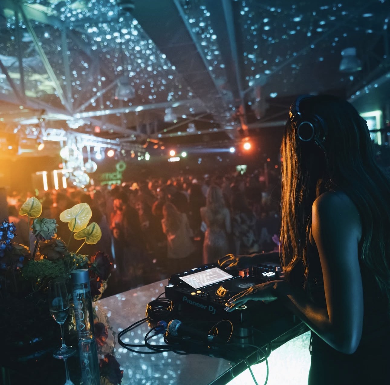 DJ behind decks at a Kollective evening with members on the floor