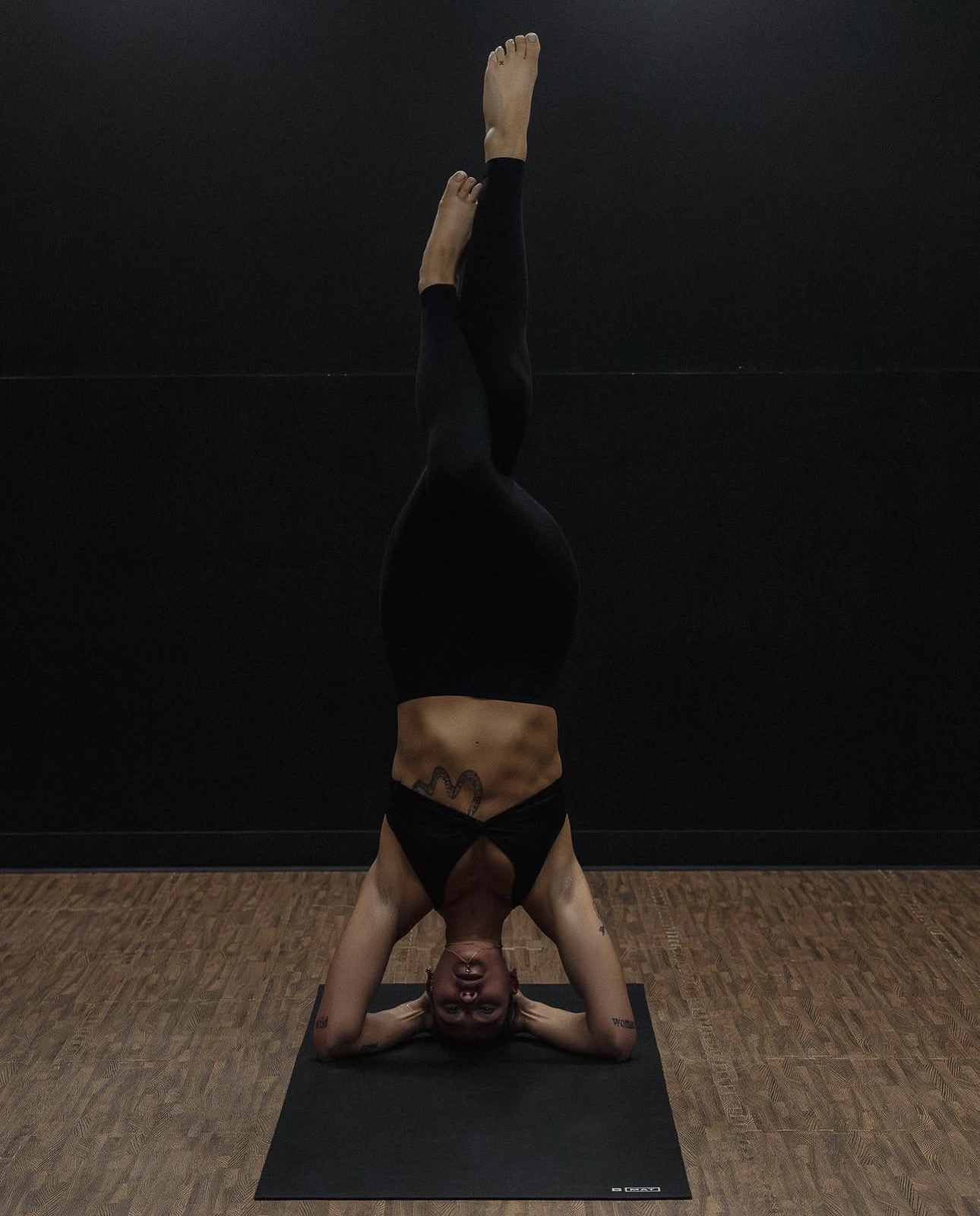 Member holding a supported headstand in the yoga studio