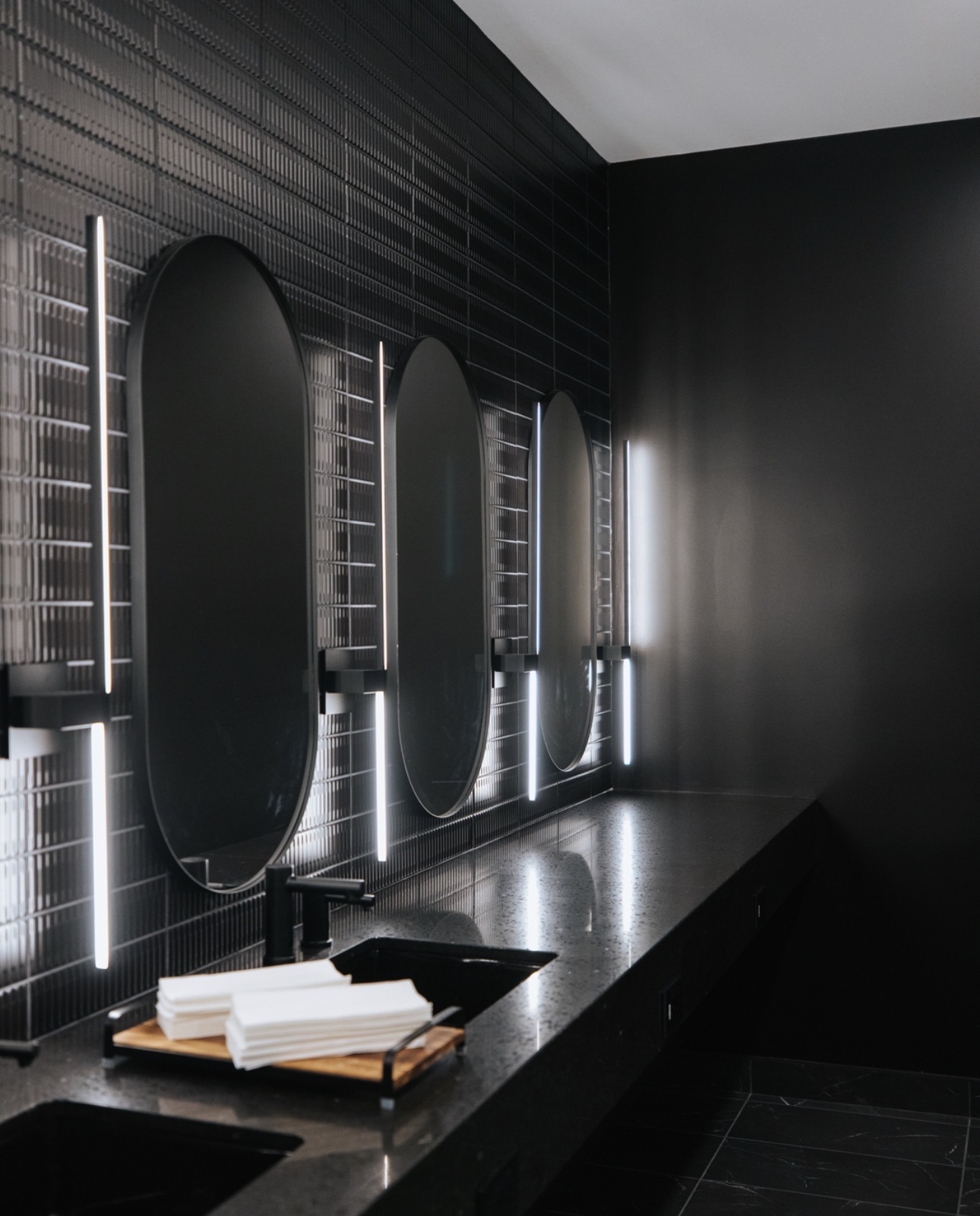 Locker room vanity with backlit oval mirrors