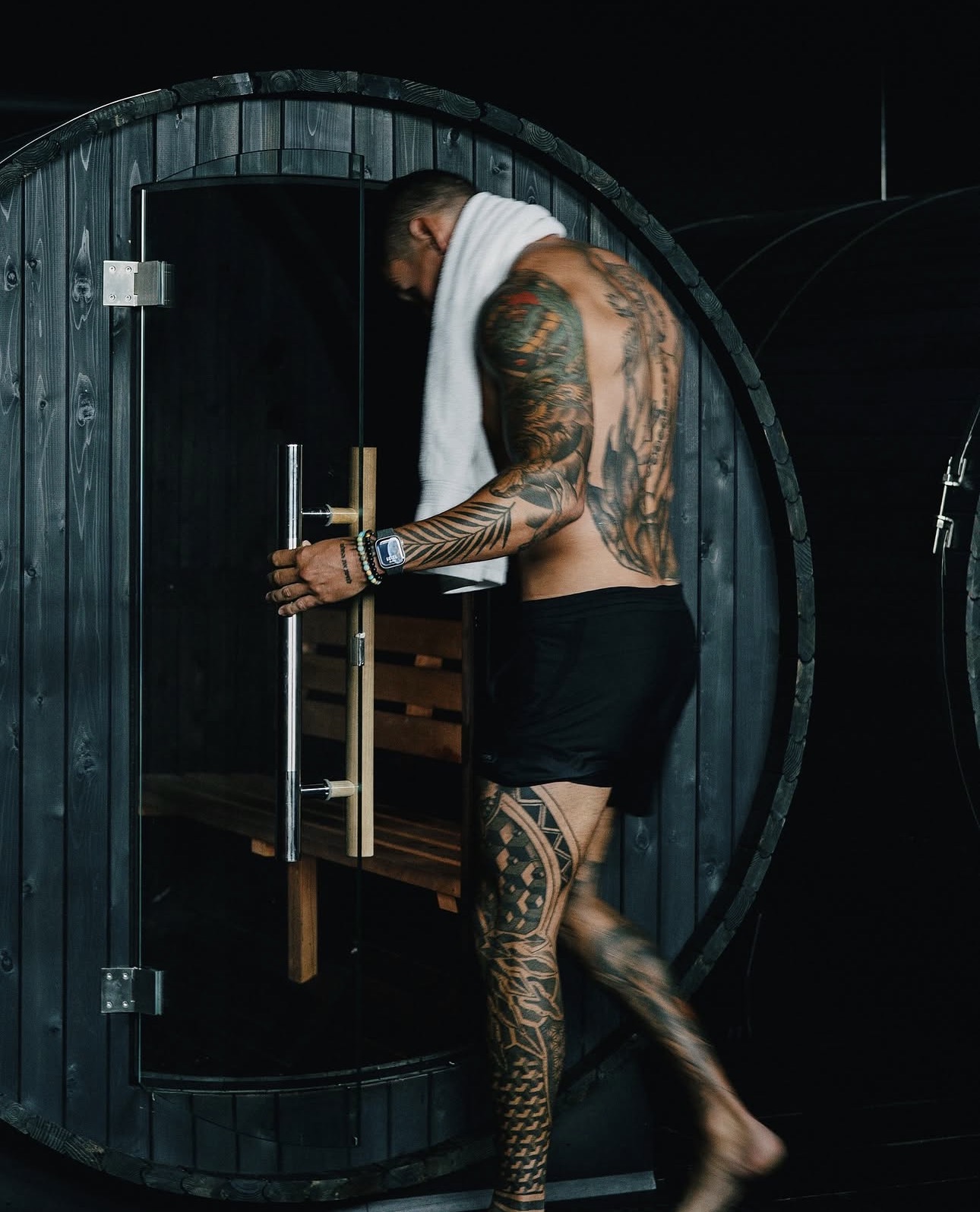 Member stepping into the barrel sauna